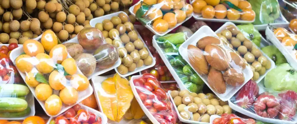 Various fruits packaged in modified atmosphere are arranged together, including longan, star fruit, orange, cherry tomatoes and other fruits